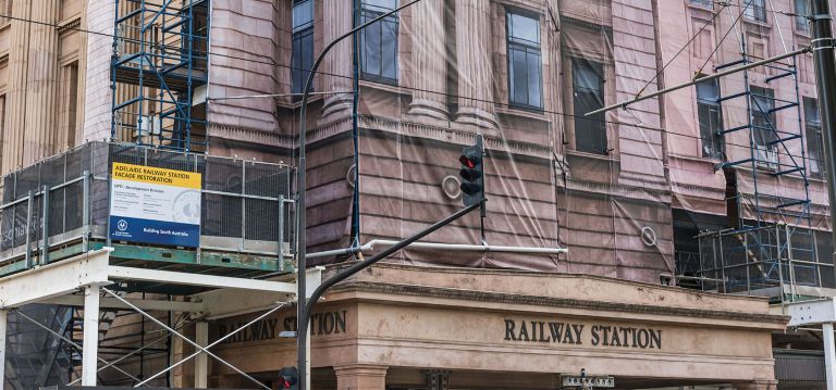 Creative mock building hoarding design overlay on Adelaide Railway Station during its heritage facade upgrade