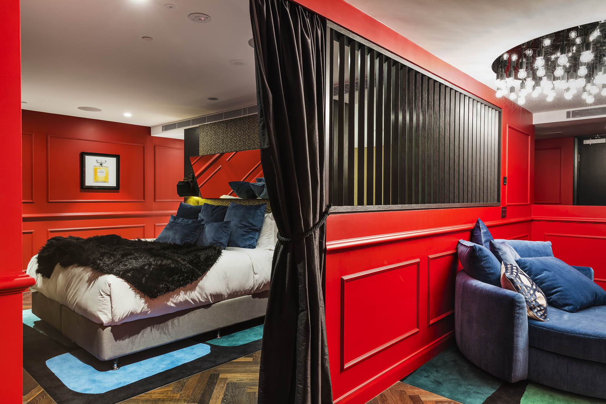 studios at the star sydney hotels design and construct nsw dark romance room red walls blue sofa chair bed black throw blanket black curtain lights black shutters