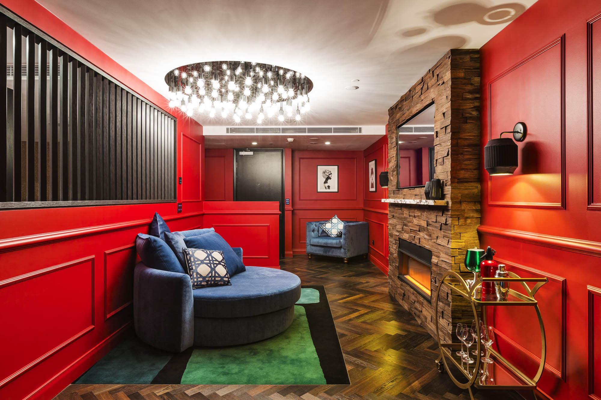 studios at the star sydney hotels design and construct nsw dark romance room red walls blue sofa chair fireplace lights drink trolley